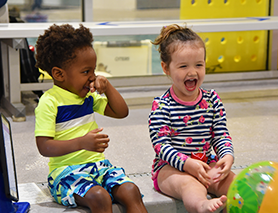 Three children swimming in a pool.